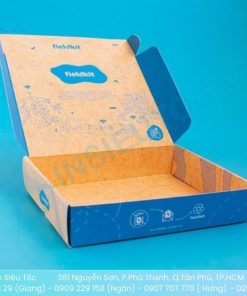 Hộp giấy đựng quần áo Tikitkits màu xanh cam đang mở với nắp in logo thương hiệu