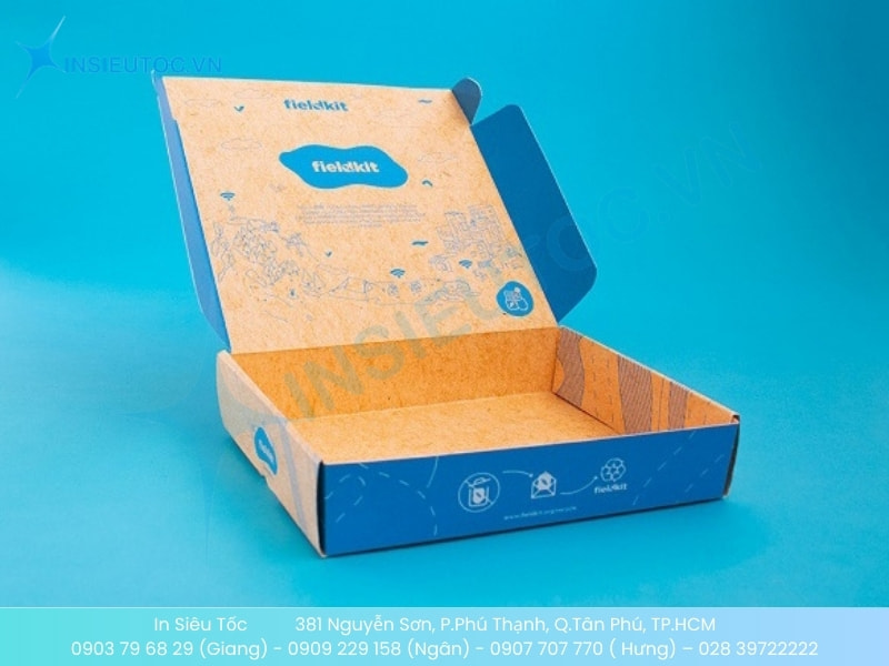 Hộp giấy đựng quần áo Tikitkits màu xanh cam đang mở với nắp in logo thương hiệu